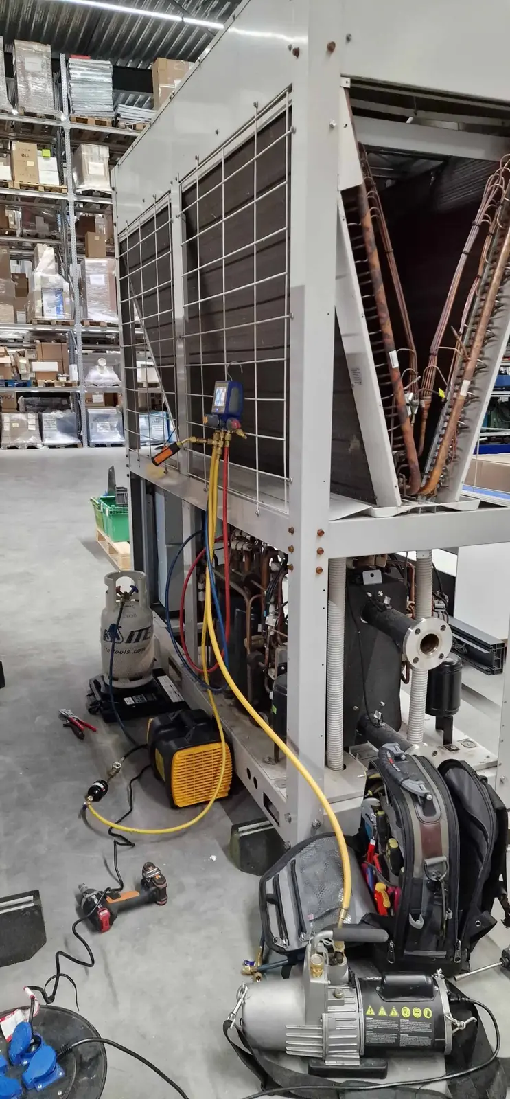 Monteur werkt aan een geopende warmtepompunit