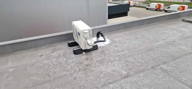 Compacte buitenunit op een plat dak
