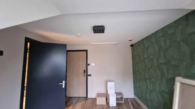 Hotelkamer met plafondunit en afgewerkte inrichting