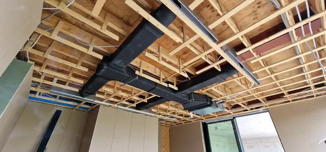 Luchtkanalen in een houten plafondconstructie