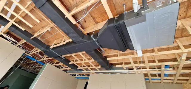 Plafondunit met luchtkanalen in een houten plafond