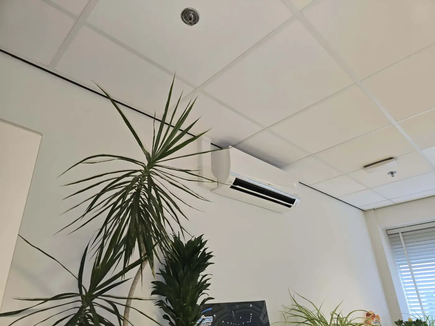 Airconditioning-wandunit in een kantoor met planten