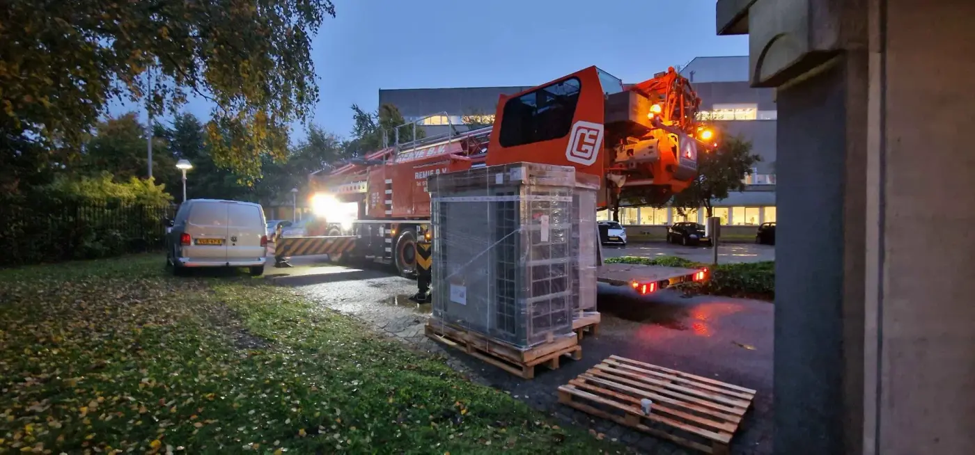 Buitenunits worden met een kraan op locatie geplaatst
