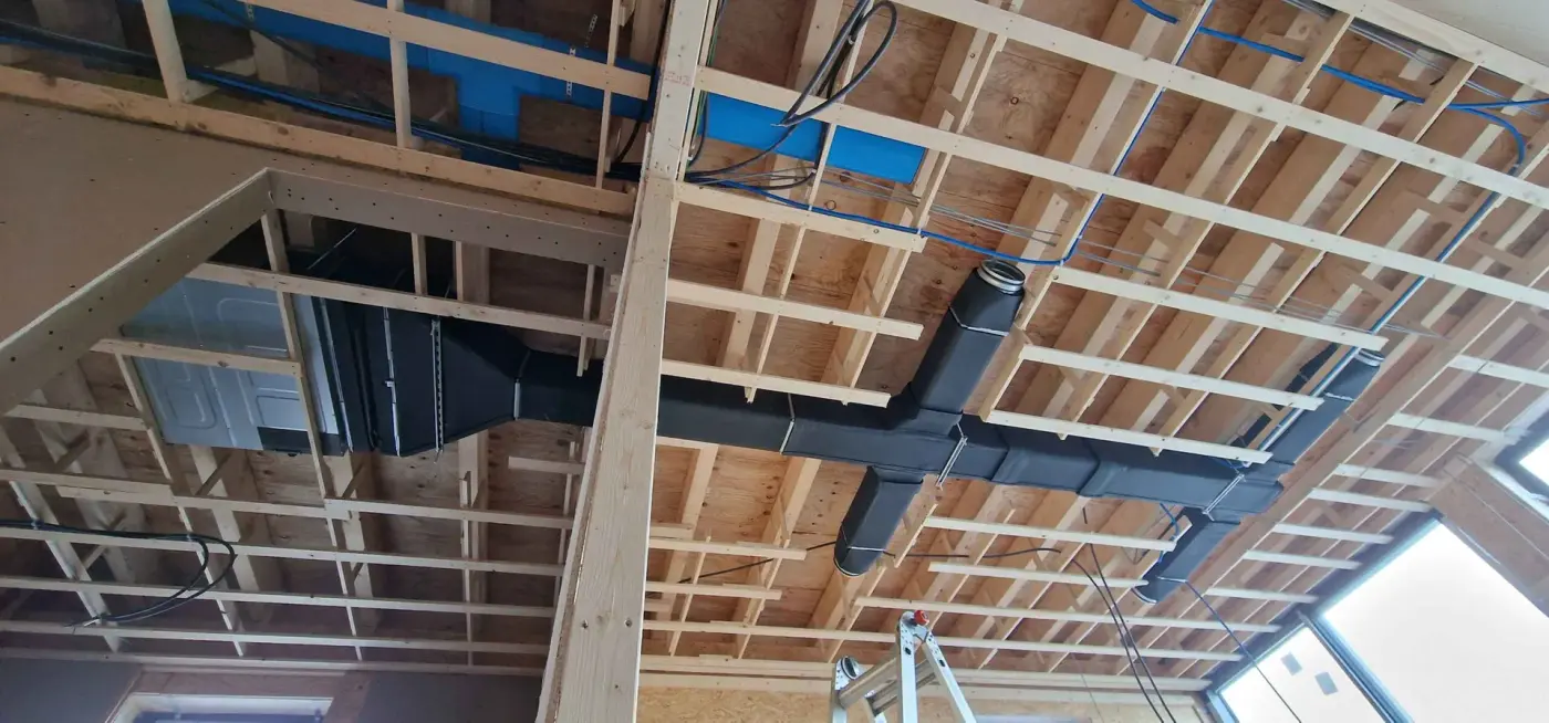 Zwarte ventilatiekanalen in een houtskeletplafond