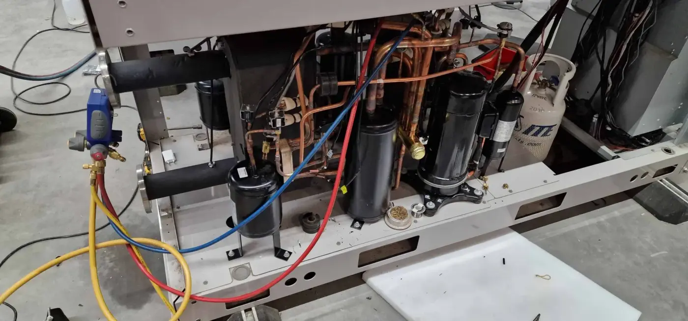 Compressoren en leidingwerk in een geopende VRF-buitenunit