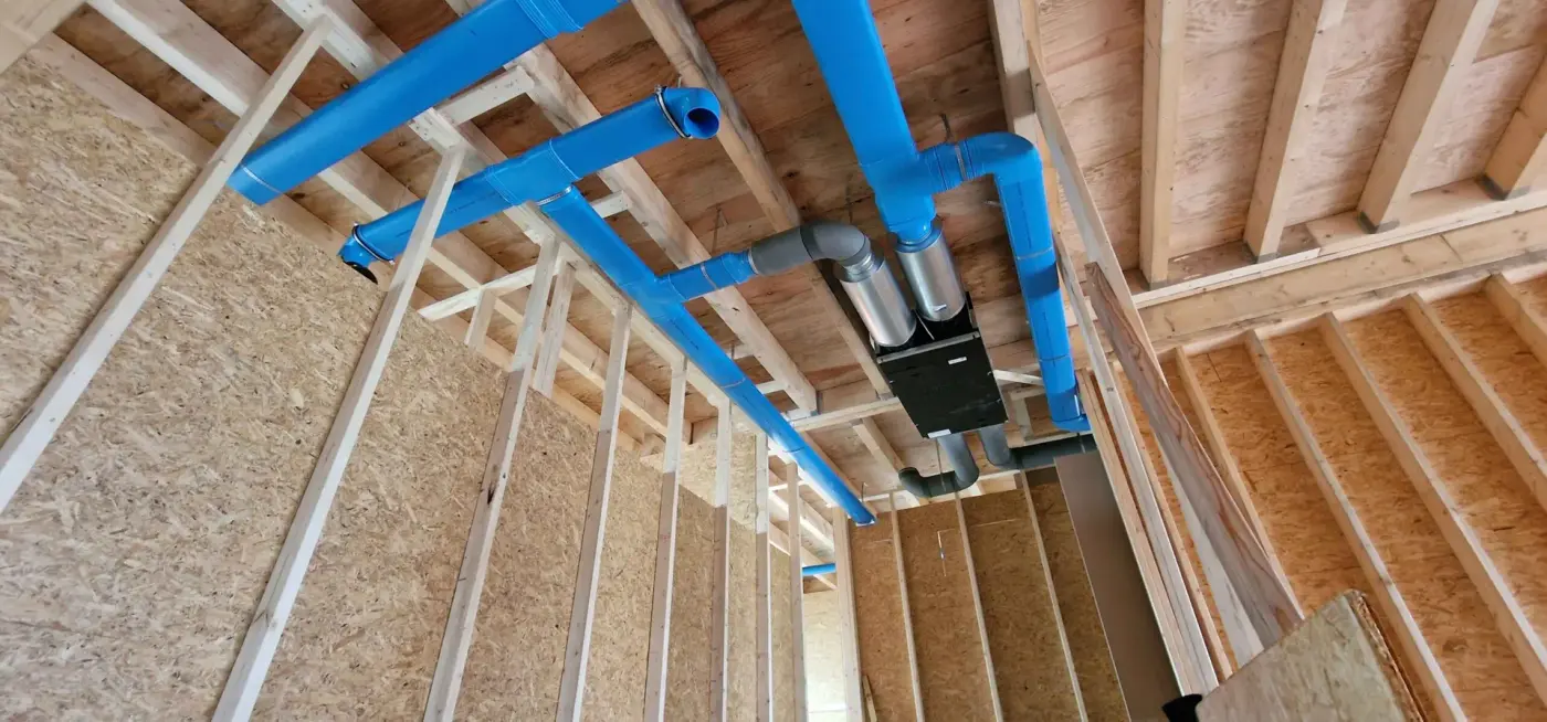 WTW-unit met blauwe luchtkanalen in een houtskeletbouw
