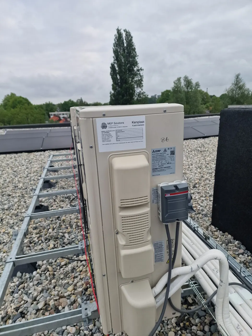Close-up van een warmtepomp-buitenunit met werkschakelaar