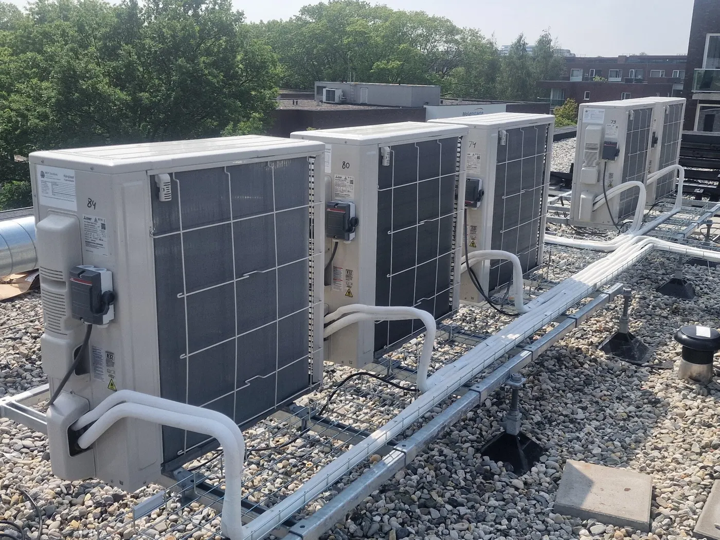 Warmtepomp-buitenunits met leidingwerk op een grinddak