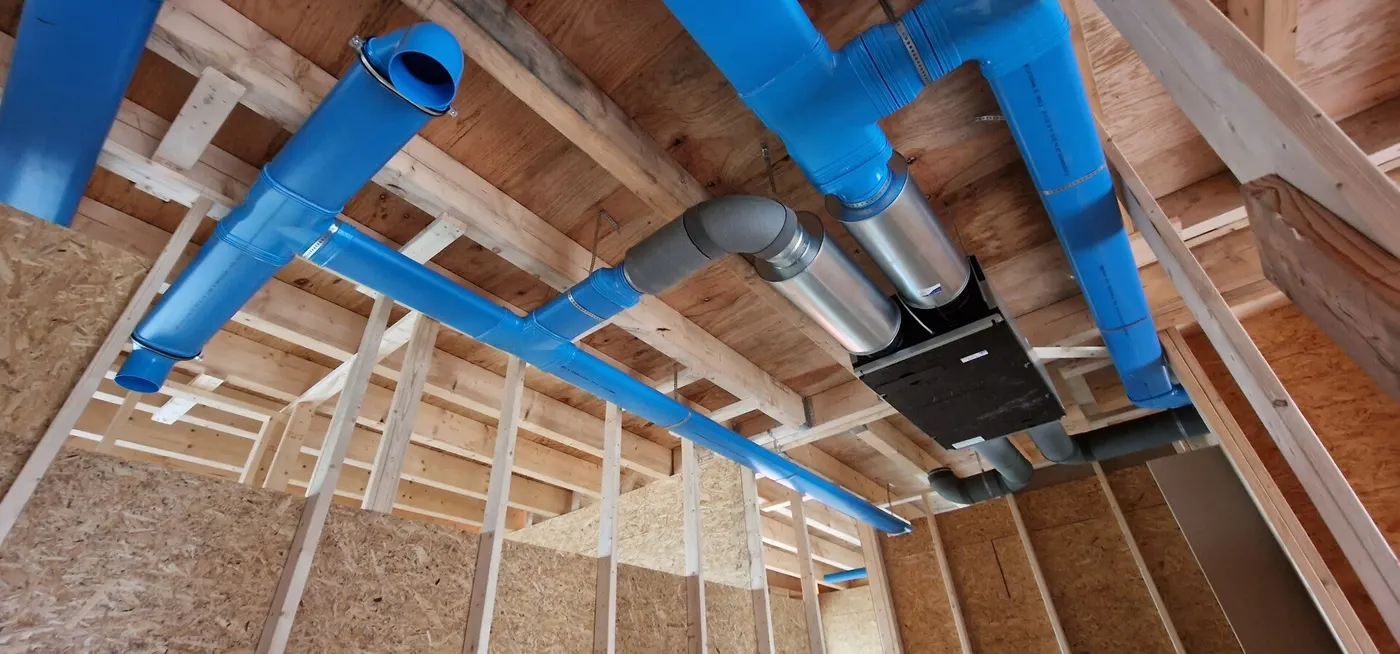 WTW-unit met blauwe luchtkanalen in een houtskeletbouw